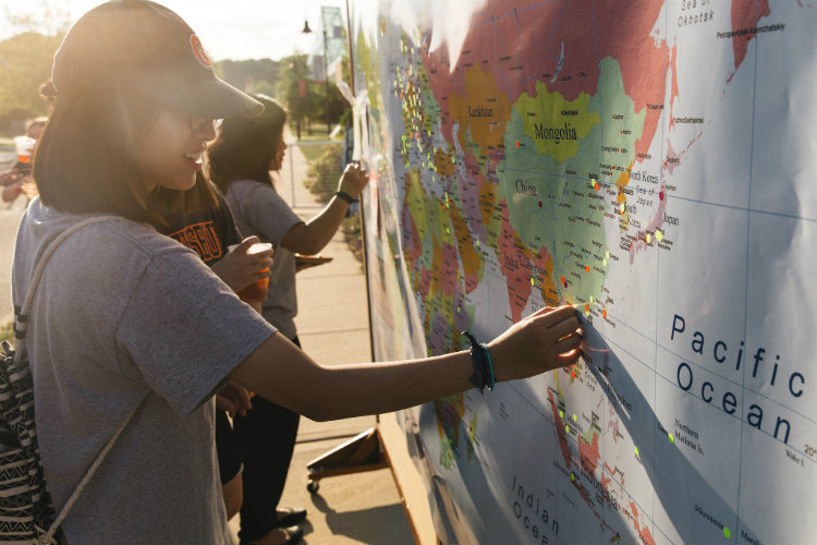 Students mark locations they’ve been on a map of the world.